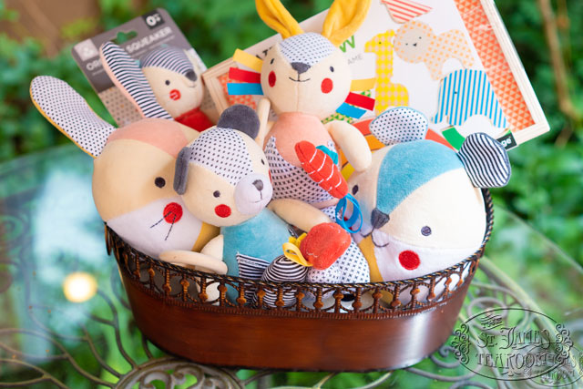 colorful plush children's toys in a bronze basket on a table