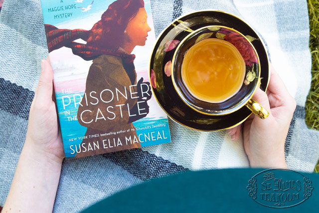 Maggie Hope Novel The Prisoner in the Castle being held with a cup of tea in a china teacup
