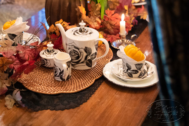 Pixel black rose china on a wood table decorated with a small pumpkin and fall leaves